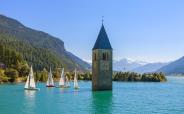 Regatta on the Reschensee – steeple of sunken Graun church